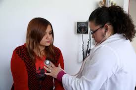 doctora revisando a paciente muejr